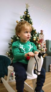 Criança a sorrir em sessão fotográfica de Natal 2025 "O Escritório do Pai Natal" em Gaia.